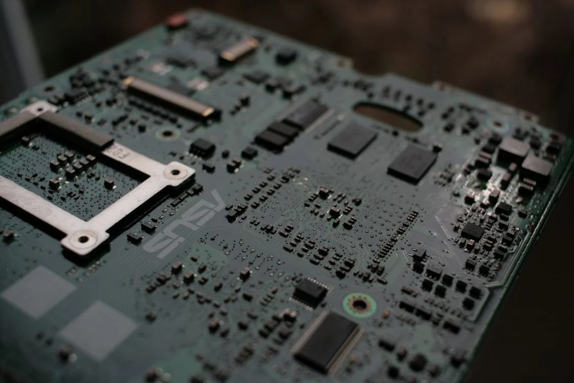 Close-up of a computer motherboard, representing the shared architecture behind delivering one consulting methodology to a hundred isolated client workspaces