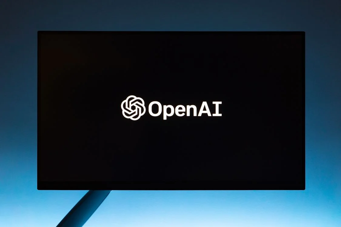 An OpenAI logo displayed on a monitor against a blue gradient, representing the general-purpose chat tools behind why generic AI doesn't work for client services