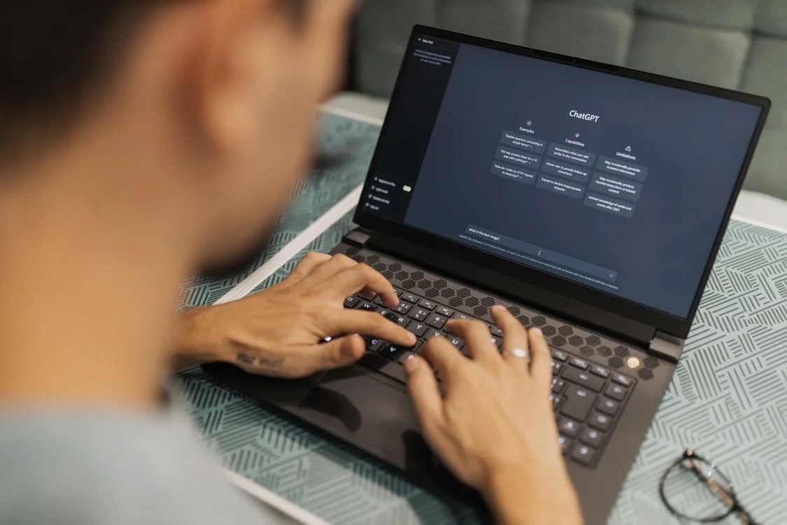 Consultant typing into a general AI chat interface on a laptop, the default setup most conversion rate optimization consultants use before per-client workspaces