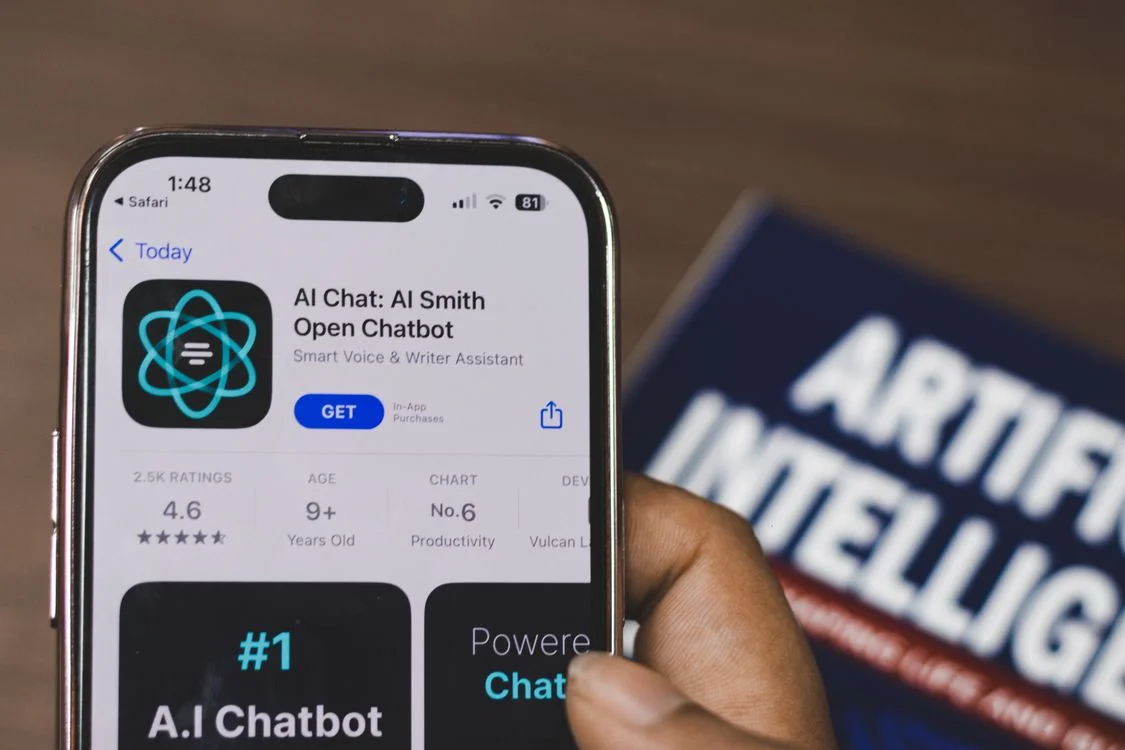 A hand holding a smartphone running an AI chatbot app, showing why business models built on packaged information stop working with AI