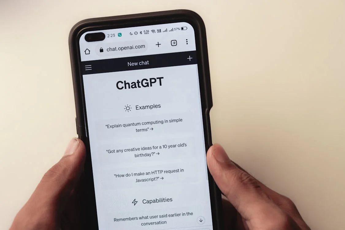 Hands holding a smartphone showing the ChatGPT app interface, the kind of generic AI tool consultants compare when weighing ChatGPT Projects vs Claude Projects