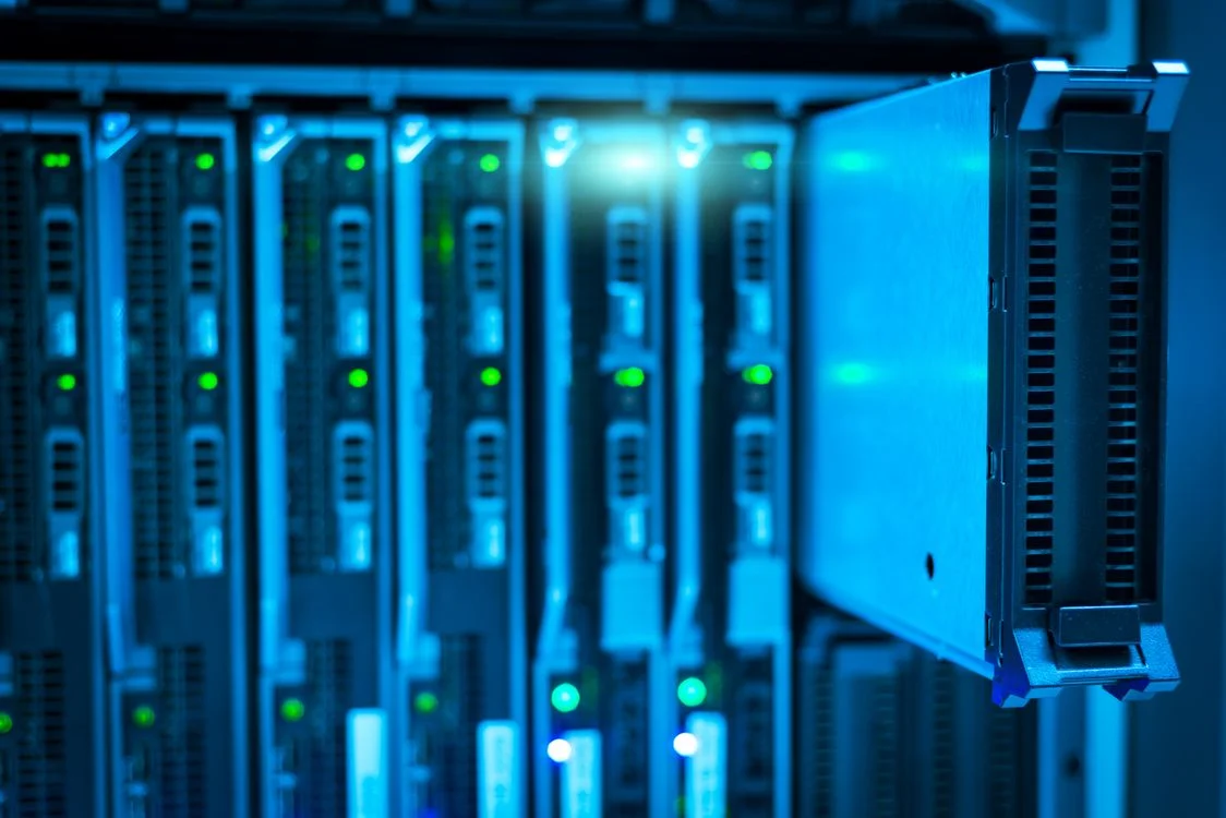 Rack of servers with status lights, representing the isolated per-client workspaces that make it safe to scale high-ticket consulting with AI