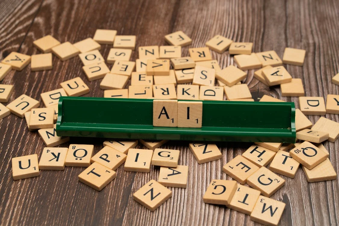 Scrabble tiles spelling AI on a wooden surface — the shift from selling information to selling intelligence applied in context