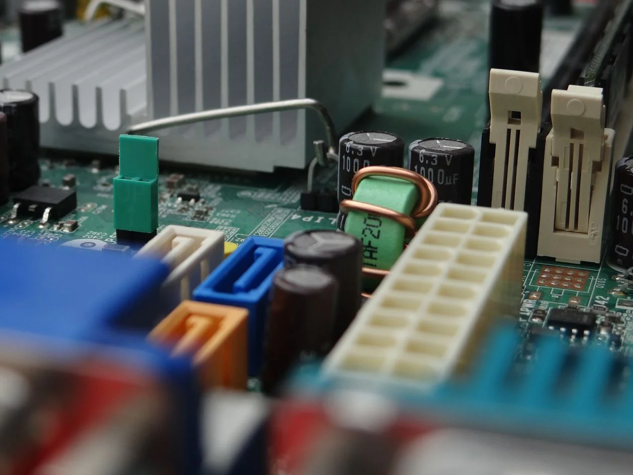 Close-up of a computer motherboard with connectors and capacitors, representing the AI knowledge base for consultants that holds a practice's methodology in one place