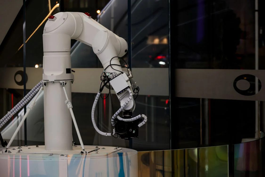 A precise white robotic arm in a modern setting, representing an AI that applies your decision-making to each client with consistency