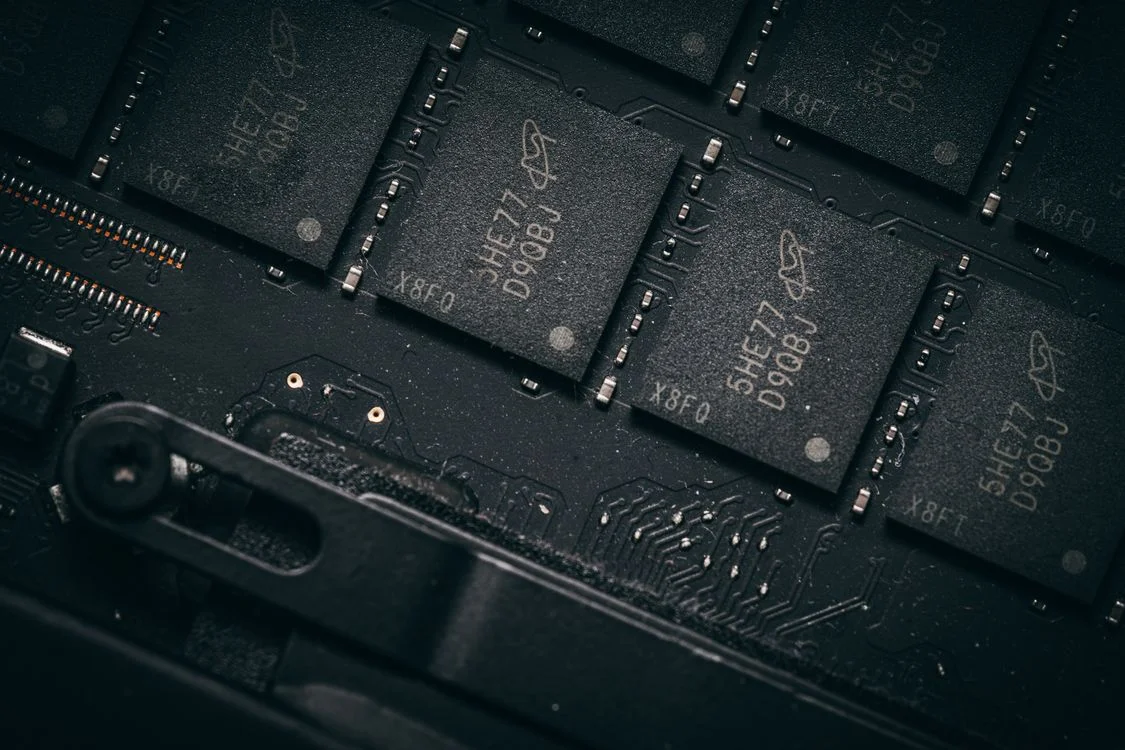 Dark macro shot of memory chips on a circuit board, representing the durable memory layer behind the future of high-ticket coaching