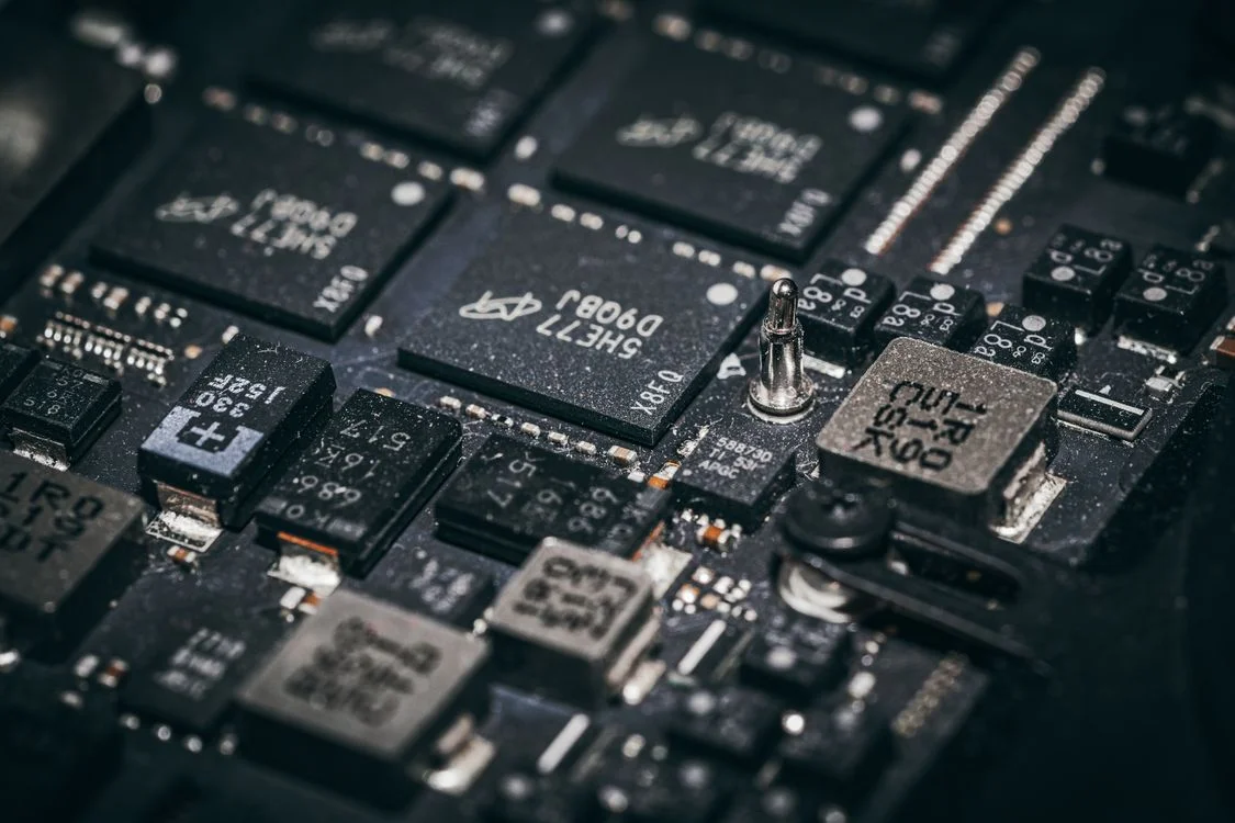 Close-up of microchips on a circuit board: AI handles the commodity half of coachsulting so the practitioner keeps the judgment half