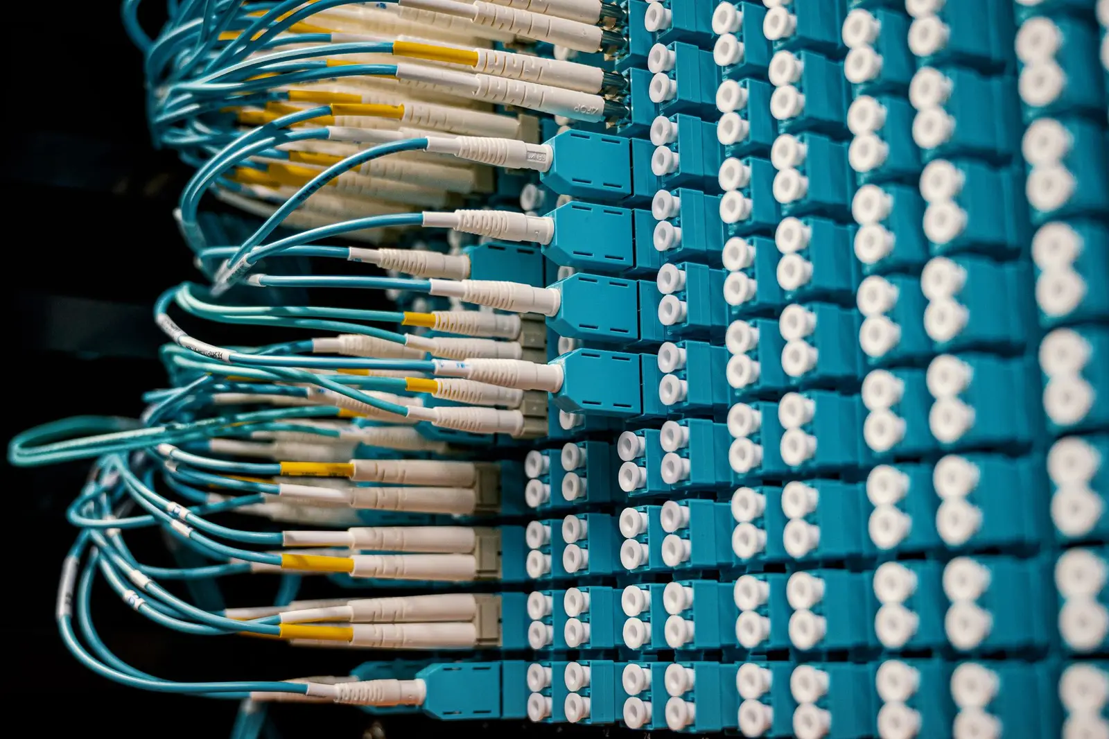 Dozens of network cables plugged into a switch panel, representing the duct-taped tool stack that most AI software for service businesses adds to