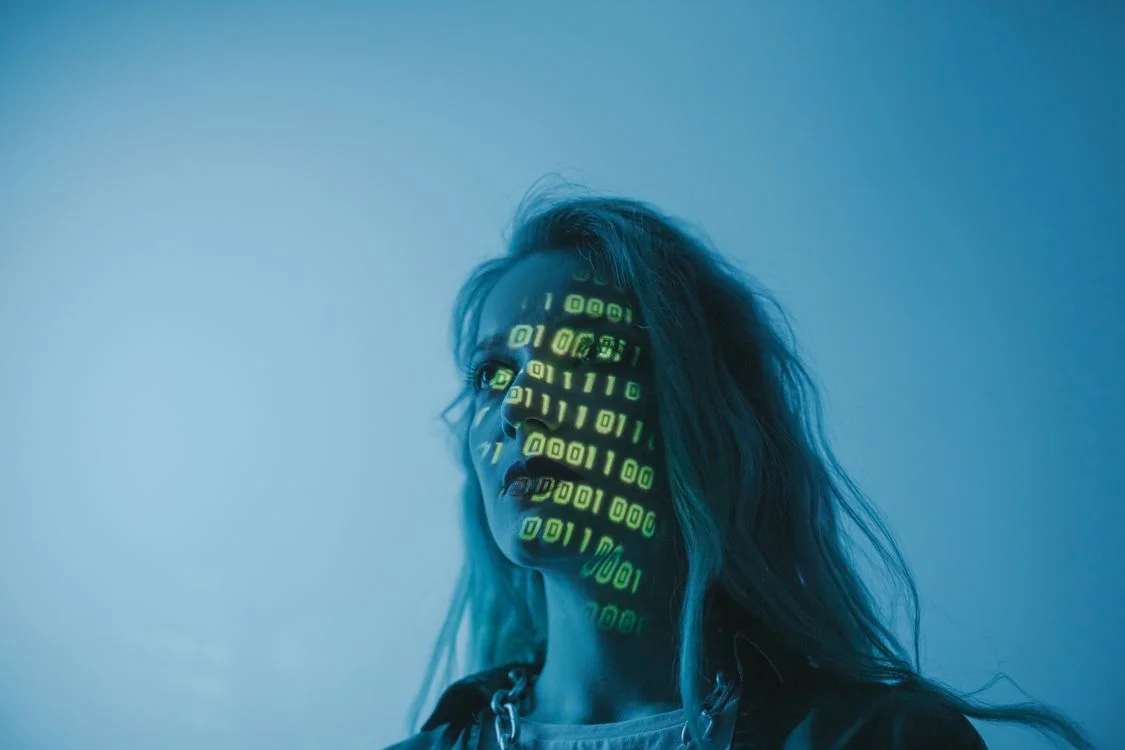 Digital code projected across a face, representing the client data and testing history a conversion rate optimization consultant has to keep isolated per client