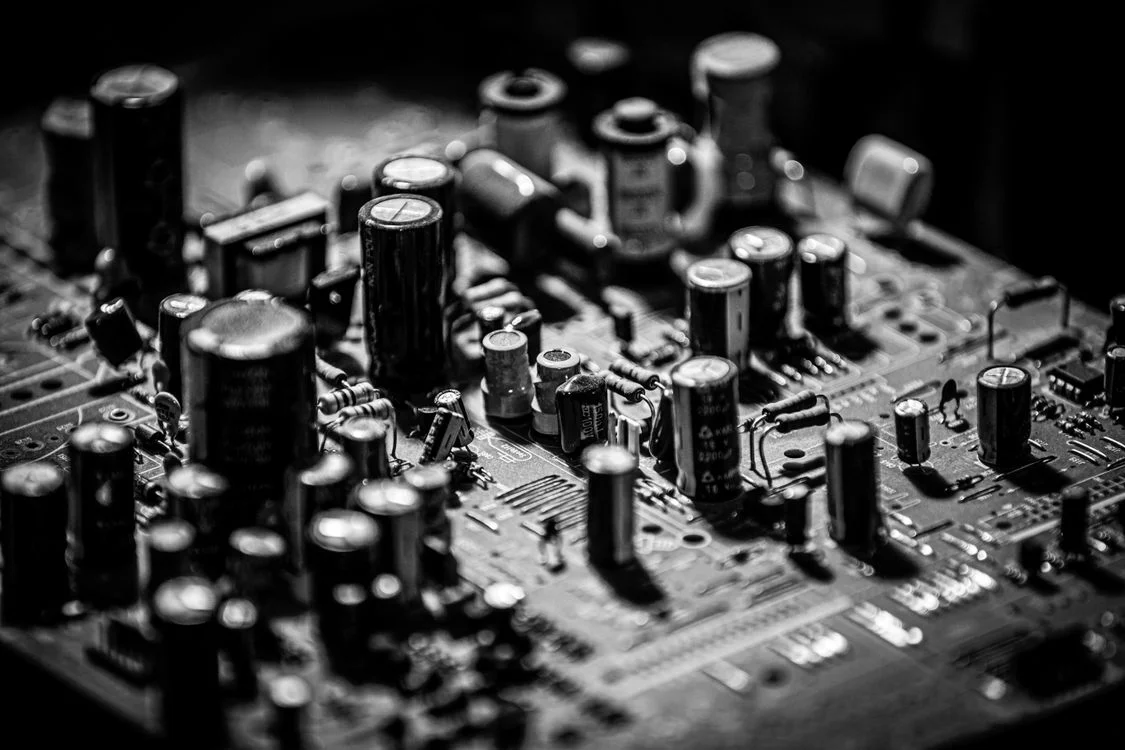 Dense black and white circuit board packed with capacitors, representing the layered data handling behind the question of whether Google Gemini is safe for client work