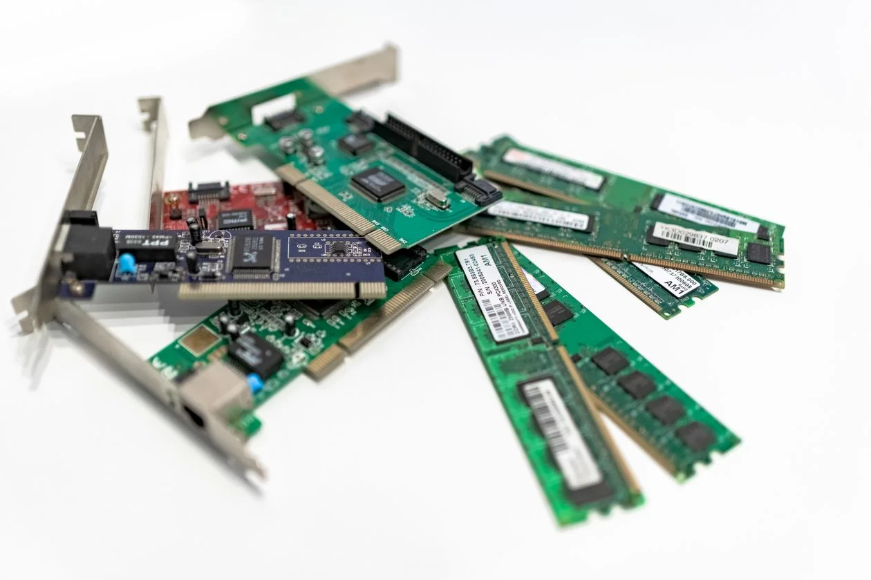 Computer RAM sticks and PCI cards arranged on a white surface, representing the difference between storing documents and running an AI knowledge base for consultants