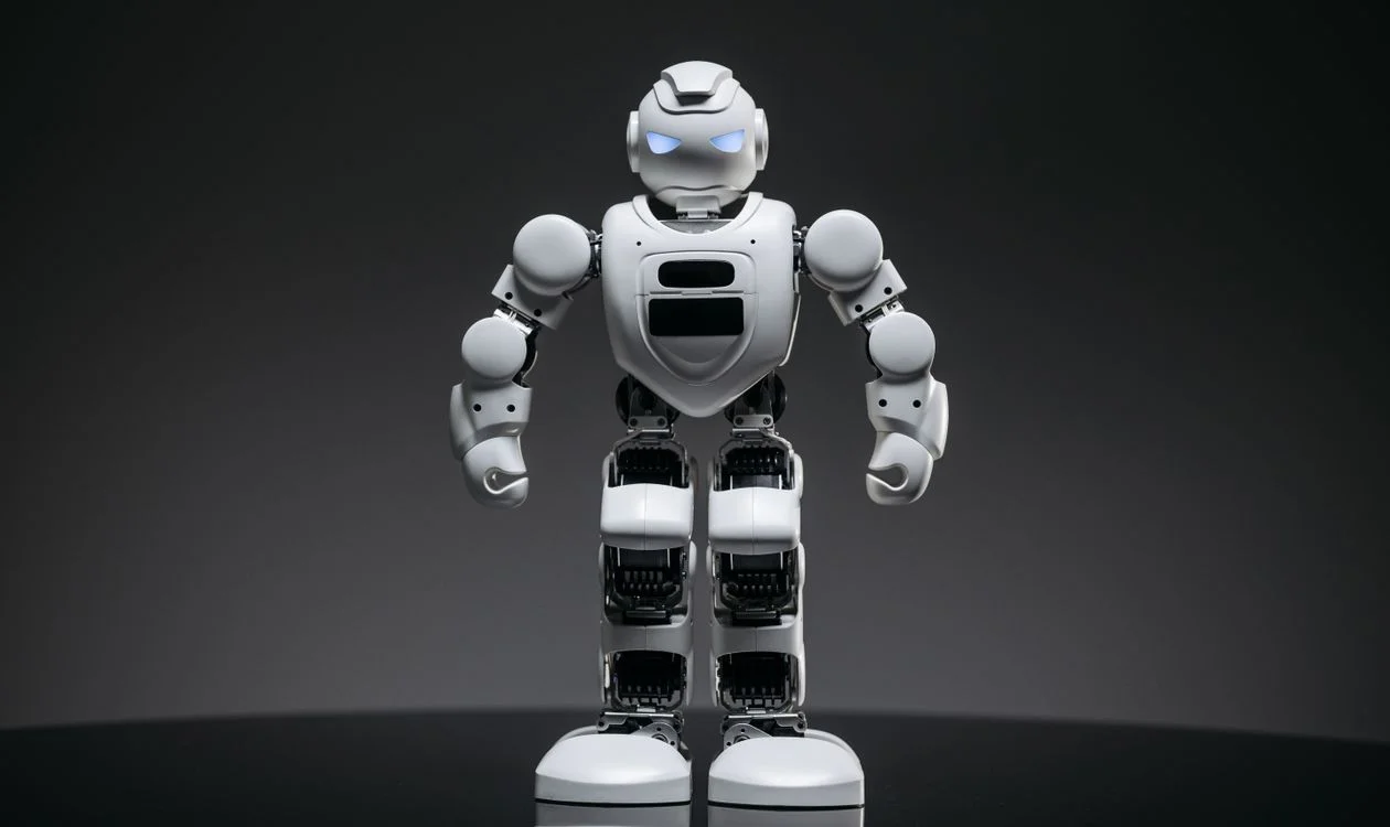 Modern white robot toy with illuminated eyes, representing captured expertise applied consistently across every client engagement