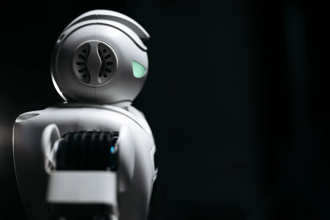 A white humanoid robot in a dark studio, representing one system running agency operations across every client account