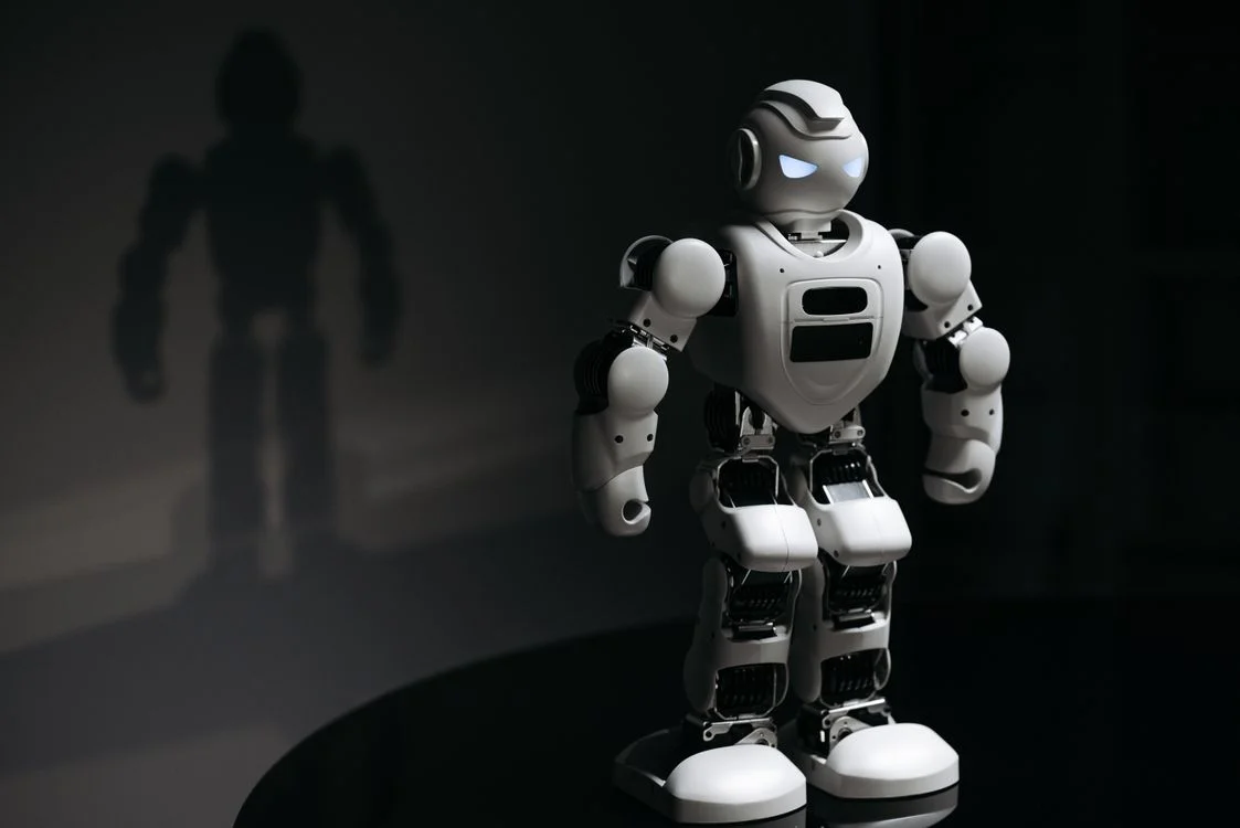 White robot with glowing eyes in dramatic studio lighting, representing the structural choice behind automating client onboarding with AI