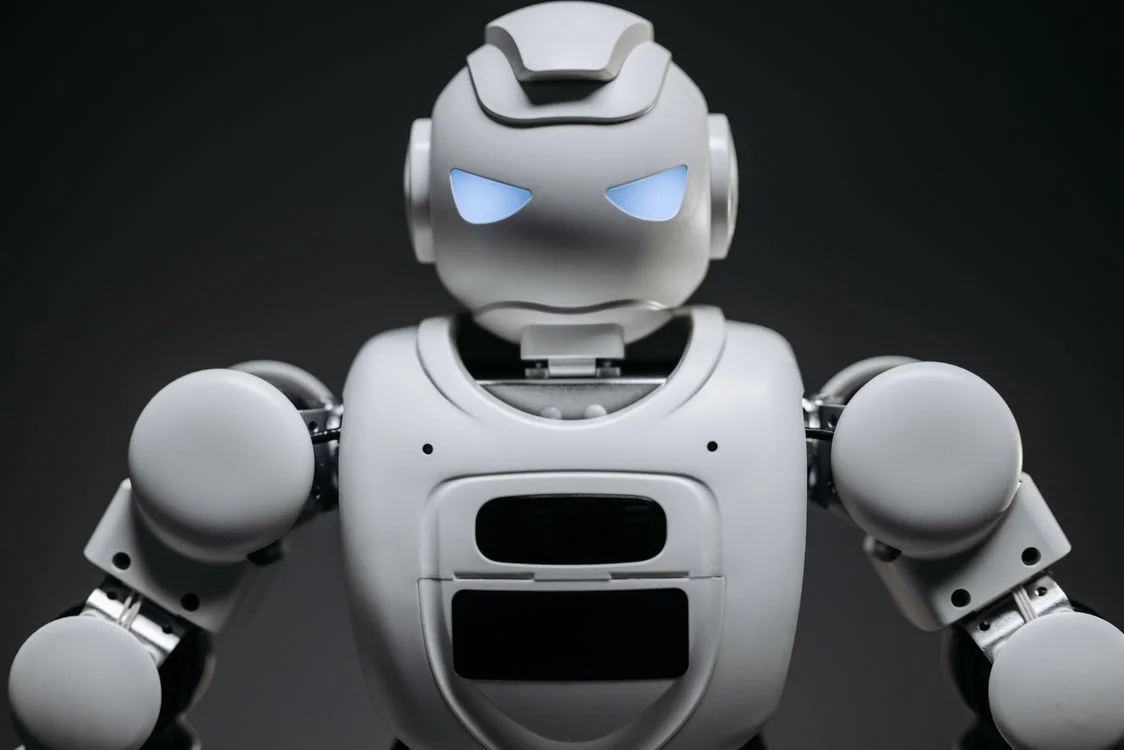 White robot with glowing blue eyes on a dark background, representing AI trained on proprietary knowledge rather than generic public data