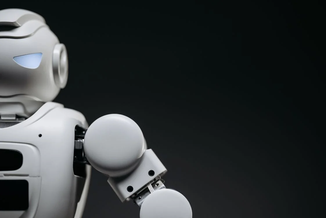 Close-up of a monochrome robot arm against a dark background, representing AI for client work where data isolation is built into the structure rather than added by hand