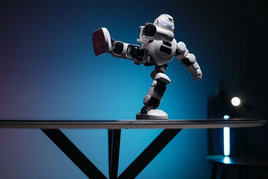 A white humanoid robot in a dynamic pose on a table lit in blue, representing a structured AI system that keeps each client sealed in an isolated workspace