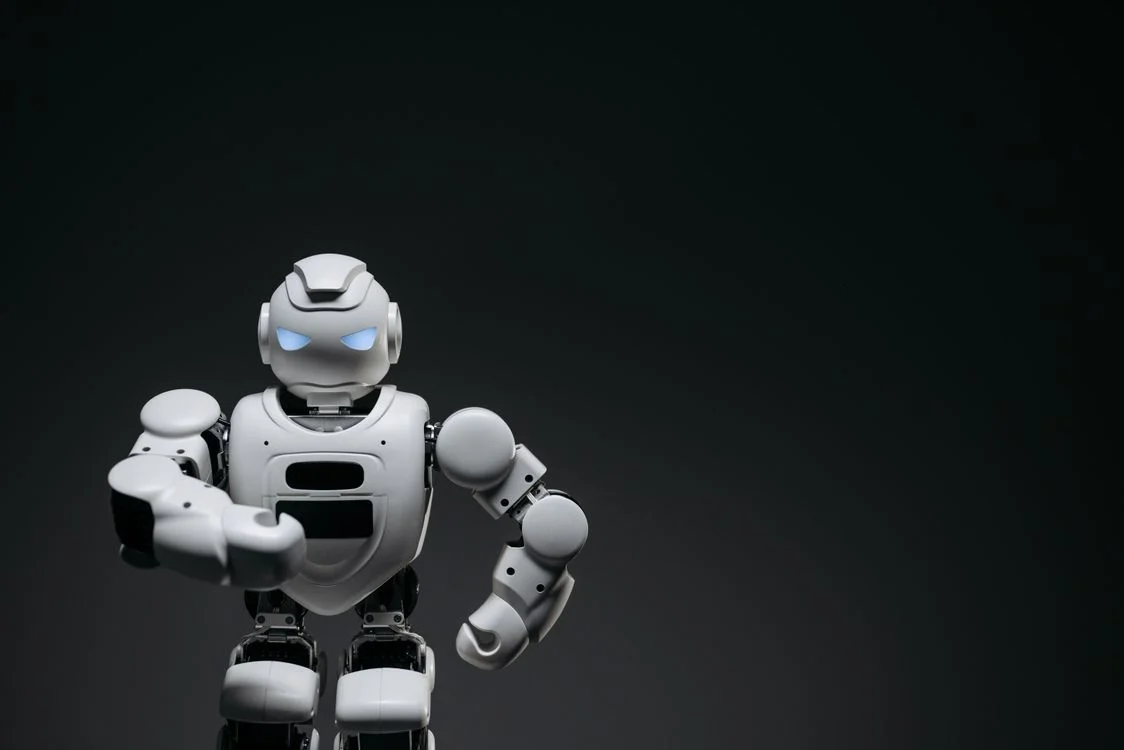 White humanoid robot in a studio, representing an AI system that holds one methodology and applies it to every client