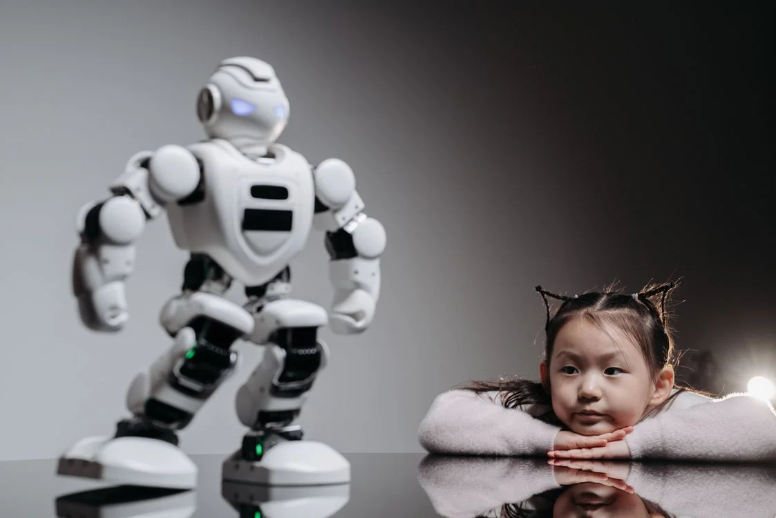 A young child watching a small humanoid robot, representing an AI system that finally understands what a client is instead of treating every chat the same