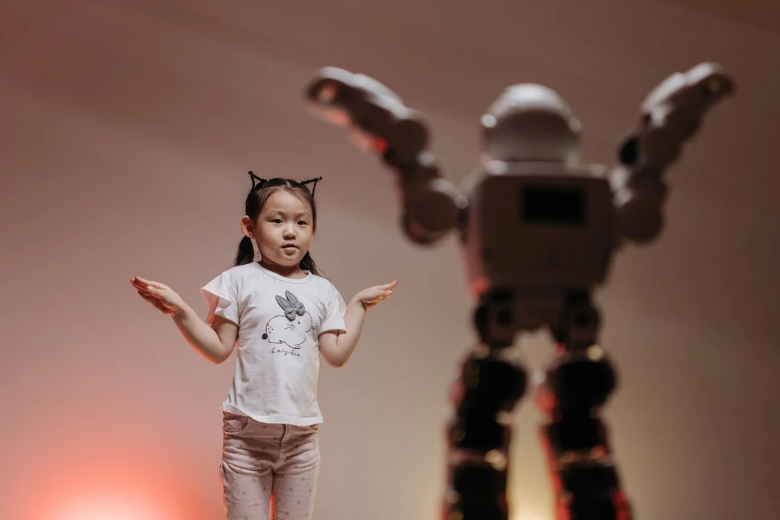 A child interacting with a humanoid robot, representing applied AI that delivers a result rather than packaged information