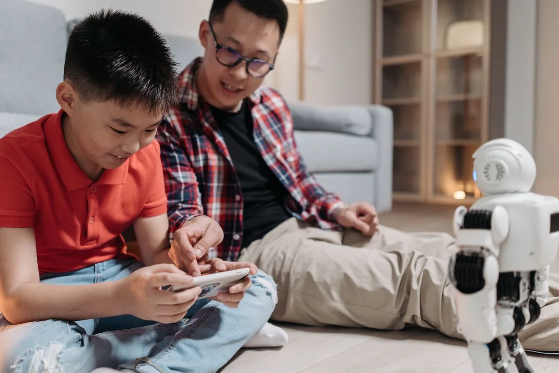 A parent and child operating a robot together, representing applied methodology delivered to a specific situation rather than sold as information