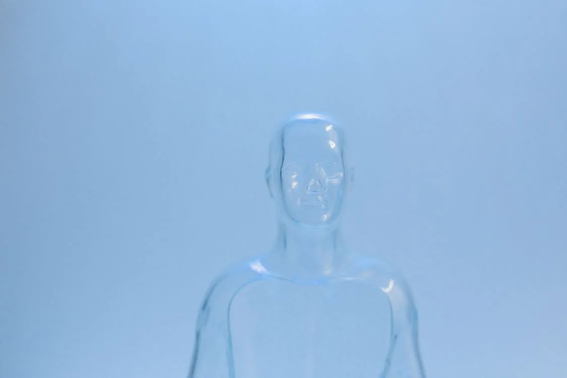 Translucent glass human figure on a pale blue background, representing AI agents for consultants that carry your expertise across every client