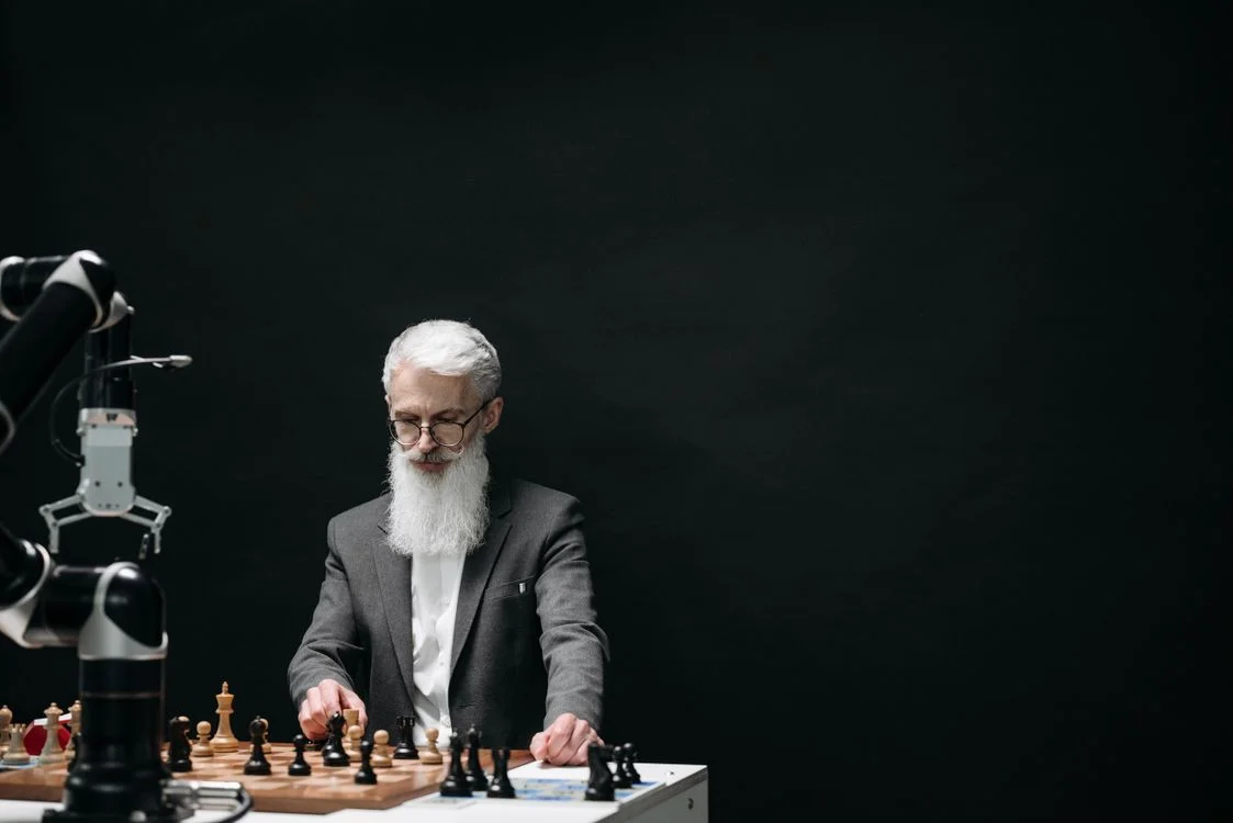 A man playing chess against a robotic arm, representing the losing effort of policing AI to stop it mixing client data manually