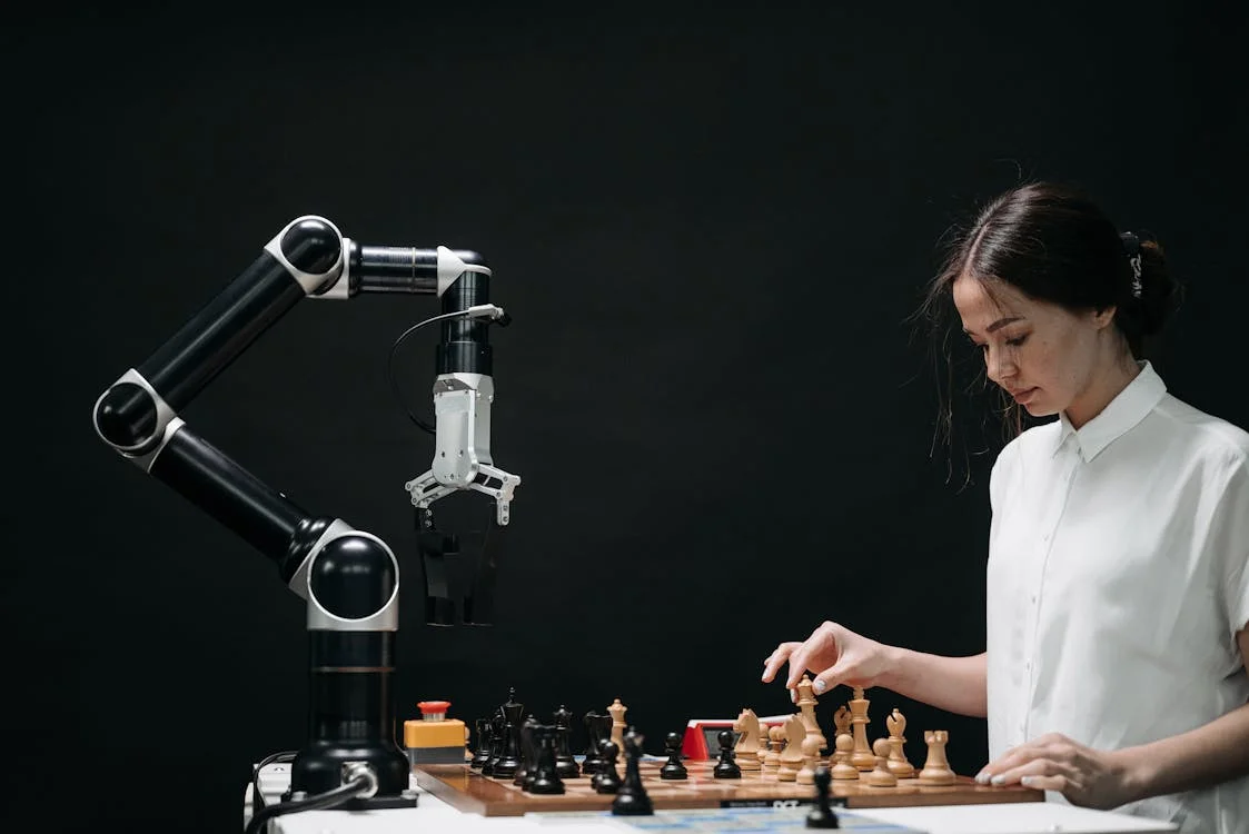 Woman facing a robotic arm across a chessboard: training AI on your consulting framework shifts the human from doing to directing