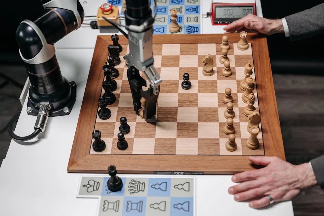 Overhead view of a robotic arm playing chess, representing AI for marketing agencies applying one methodology across every client account