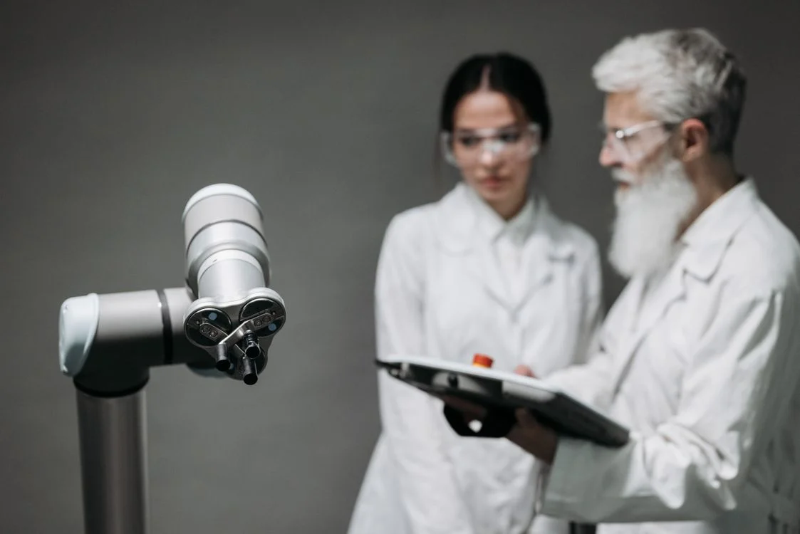 Two researchers reviewing a robotic arm in a lab, representing the audit needed to prevent AI from mixing client data