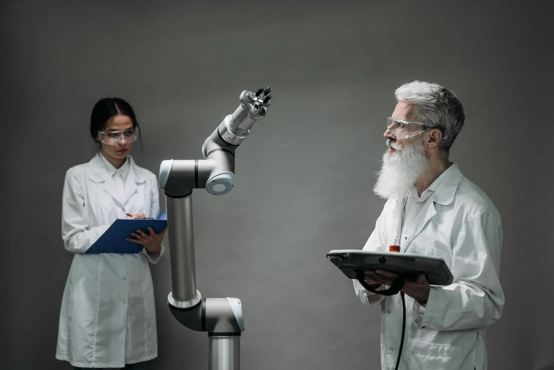 Two researchers in lab coats calibrating a robotic arm, representing consultants building an AI agent from their own frameworks