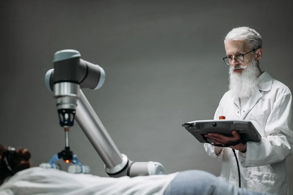 A scientist directing a robotic arm with a handheld controller, representing the review seat you move into when a system applies your methodology to every client