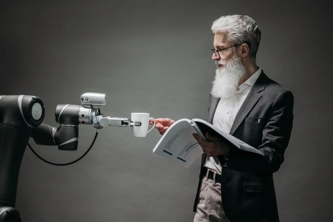 Researcher working alongside a robotic arm in a lab, illustrating proprietary knowledge loaded into an AI system that applies it consistently