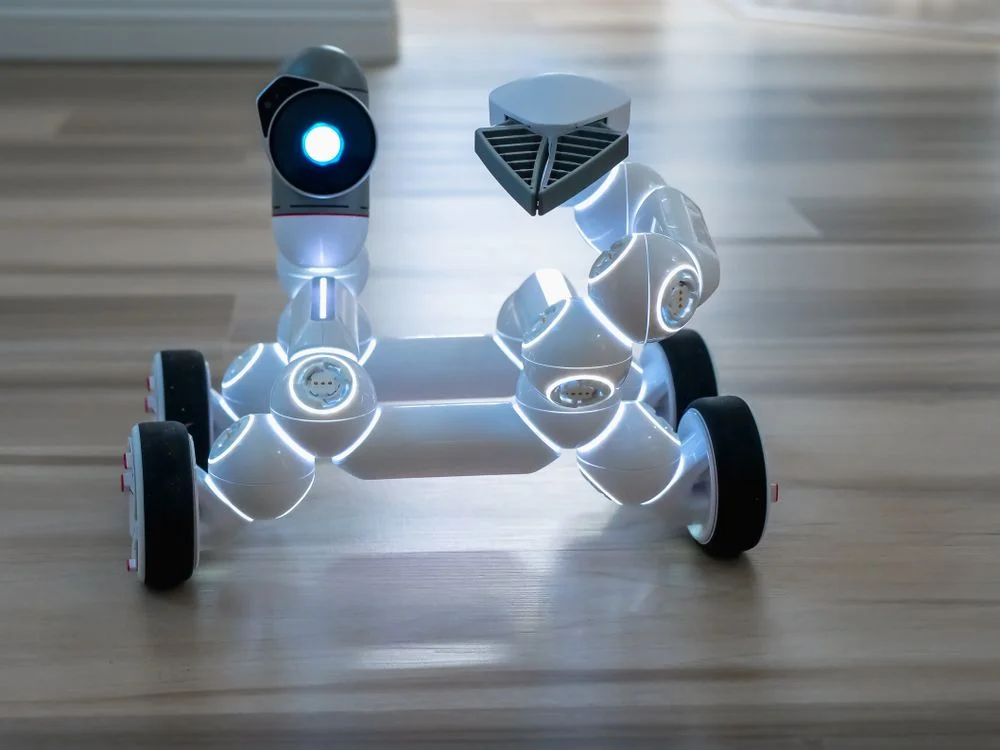 A white robot with illuminated joints, representing one AI system that runs a single methodology across separate AI workspaces per client